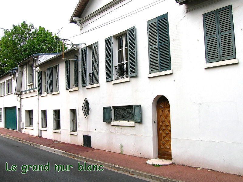 20 Le grand mur blanc avec la porte de bois et le soupirail
